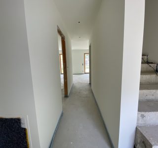 Massiv Treppenaufgang und Zugang zum offenen Koch-Essbereich-Wohnen